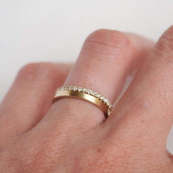 Mulher usando Aliança de 1,5mm cravejada de diamantes minimalista feita a mão em ouro 18k para casamentos