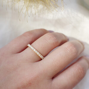 Mulher usando Aliança de 2mm cravejada de diamantes minimalista feita a mão em ouro 18k para casamentos