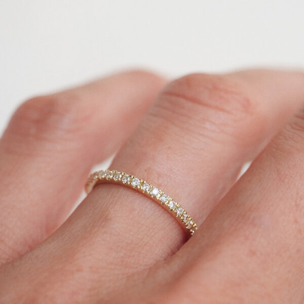 Mulher usando Aliança slim cravejada de diamantes minimalista feita a mão em ouro 18k para casamentos