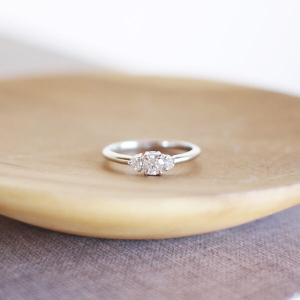 Anel de noivado minimalista feito a mão em ouro 18k com diamante de 38p sobre prato de madeira