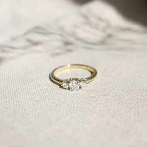 Anel de noivado minimalista feito a mão em ouro 18k com diamante de 38p sobre tecido cru