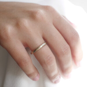 Mulher usando Aliança de casamento feita a mão em ouro 18k de 2mm facetada minimalista