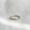 Aliança de casamento feita a mão em ouro 18k de 2mm facetada minimalista sobre tecido branco