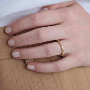 Mulher usando Aliança de aro redondo 2,4mm minimalista feita a mão com diamantes em ouro 18k para casamentos