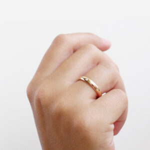 Mulher usando Aliança minimalista boleada feita a mão em ouro 18k com diamante para casamentos
