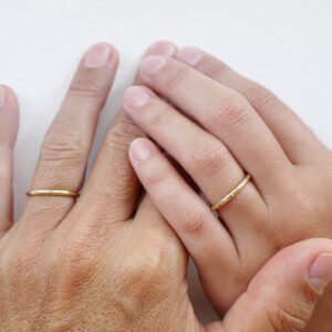 Casal usando Par de alianças de aro redondo 1,8mm com diamantes minimalistas feitas a mão em ouro 18k para casamentos