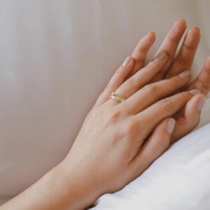 Mão feminina usando aliança de 4mm minimalista feita a mão em ouro 18k com diamantes para casamentos