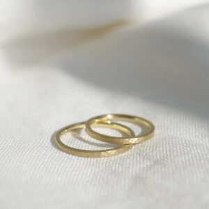 Par de Alianças minimalistas marteladas feitas a mão em ouro 18k sobre tecido branco