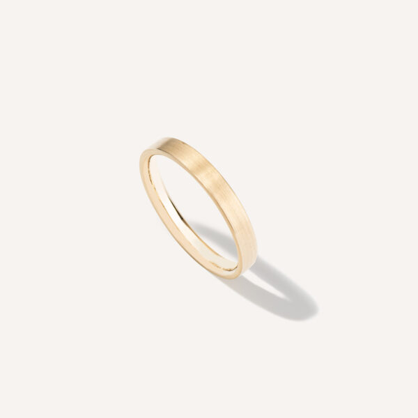 aliança de casamento feita à mão em ouro 18k e minimalista sobre fundo branco