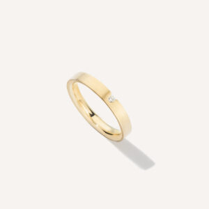aliança de casamento feita a mão em ouro 18k e diamante central de 3 pontos minimalista sobre fundo branco