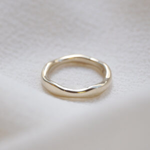 Aliança irregular orgânica minimalista feita a mão em ouro 18k para casamentos sobre tecido