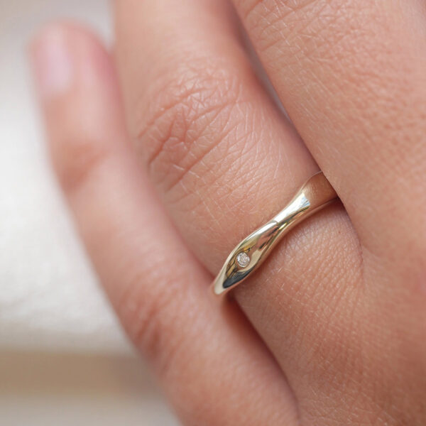 Mão usando Aliança irregular orgânica minimalista feita a mão em ouro 18k para casamentos