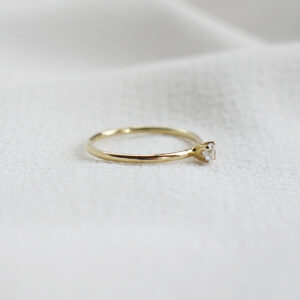 Anel de noivado minimalista feito a mão em ouro 18k com diamante sobre tecido branco