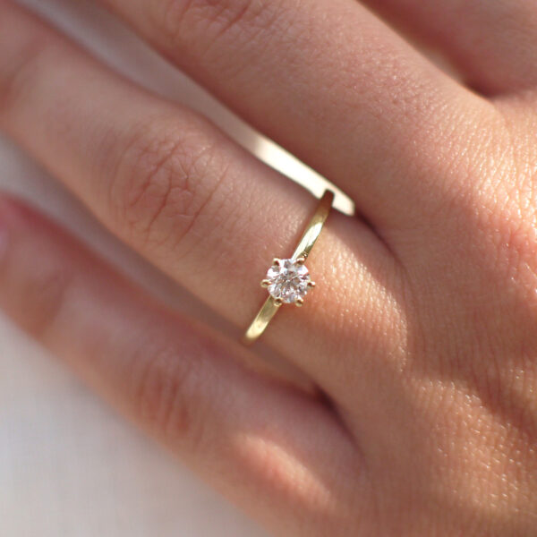 Mulher usando anel solitário minimalista com diamantes de 30p em ouro 18k