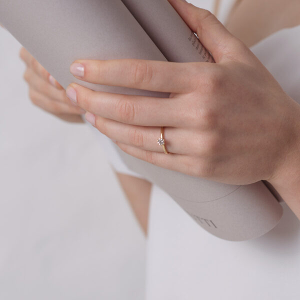 Mulher usando anel solitário minimalista com diamantes de 30p em ouro 18k
