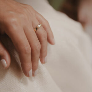 Mão feminina usando Aliança minimalista feita a mão em ouro 18k com diamante para casamentos
