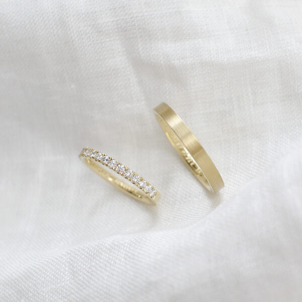 Par de alianças minimalistas feitas a mão em ouro 18k para casamentos sobre tecido branco
