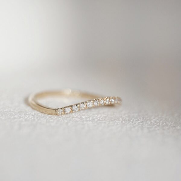 Aliança cravejada minimalista feita a mão em ouro 18k para casamentos sobre tecido branco