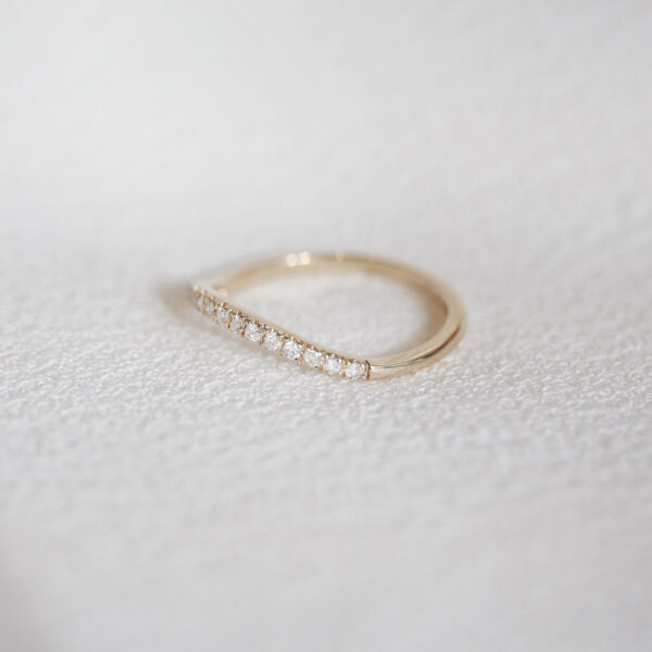 Aliança cravejada minimalista feita a mão em ouro 18k para casamentos sobre tecido branco