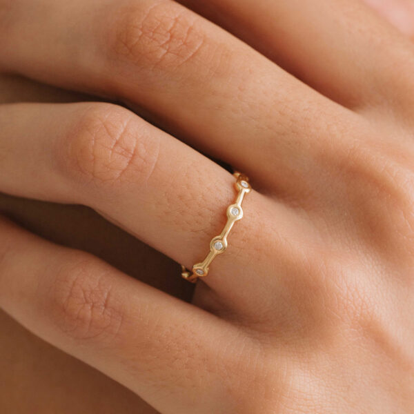 Mão com aliança minimalista em ouro 18k feita a mão com diamantes para casamentos