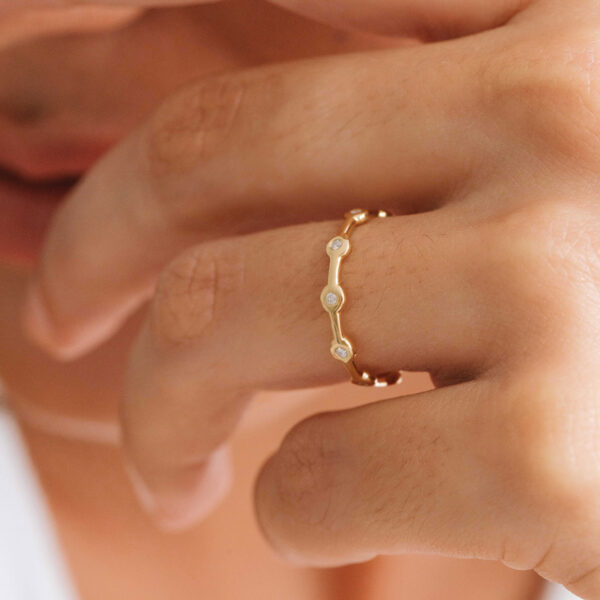 Mão com aliança minimalista em ouro 18k feita a mão com diamantes para casamentos