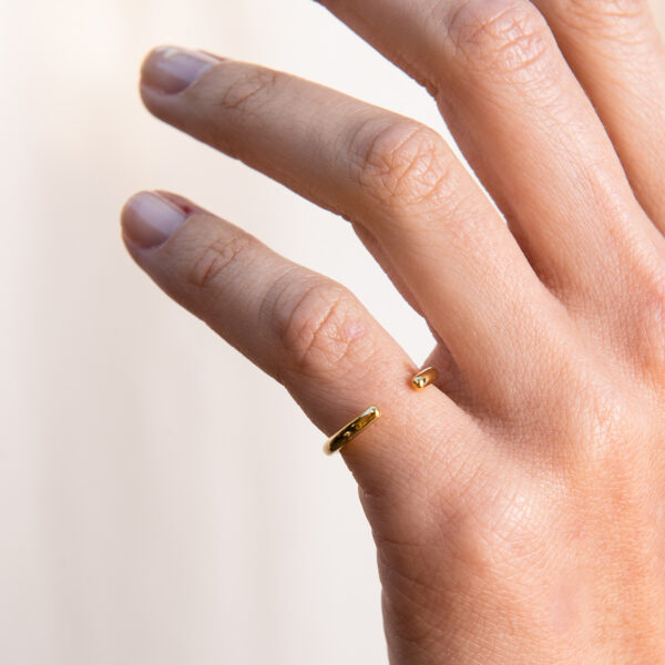 Mão feminina usando Anel aberto minimalista em ouro 18k feito a mão com aro arredondado