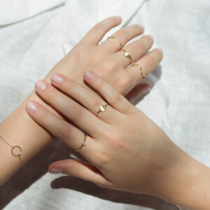 Mulher usando anéis minimalistas em ouro 18k feitos a mão