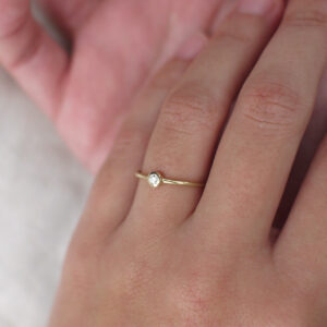 Mão vestindo Anel de aro arredondado minimalista feito a mão em ouro 18k com diamante
