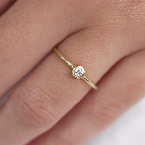 Mão vestindo Anel de aro arredondado minimalista feito a mão em ouro 18k com diamante