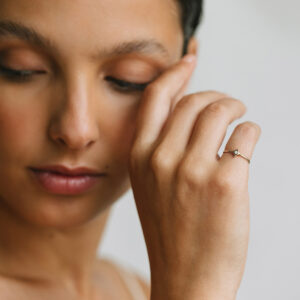 Mulher usando Anel minimalista feito a mão em ouro 18k com estrela e diamante no centro