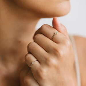 Mulher usando Anéis minimalistas feitos a mão em ouro 18k com estrela e diamante no centro