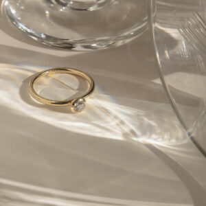 anel de noivado em ouro 18k e diamante minimalista e feito à mão sobre mesa