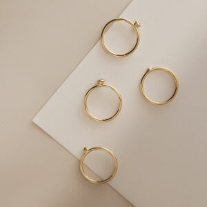 anéis de noivado de ouro 18k e diamantes minimalistas e feitos à mão sobre mesa branca