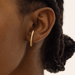 Mulher usando Brinco minimalista contorna a orelha feito a mão em ouro 18k em formato de C