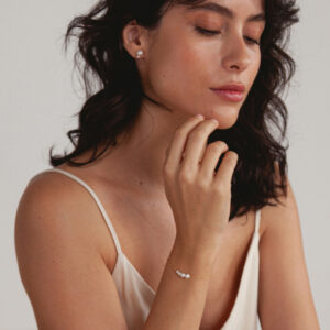 Mulher usando Pulseira, Colar e Brinco minimalistas feitos a mão em ouro 18k com pérolas naturais em tamanhos diferentes