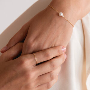 Mulher usando pulseira e Anel minimalista feito a mão com corrente em ouro 18k e diamante