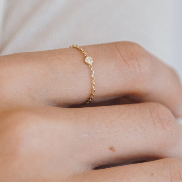 Mão vestindo Anel minimalista feito a mão com corrente em ouro 18k e diamante