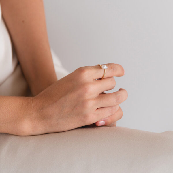 Mulher usando anel 18k minimalista feito a mão com pérolas naturais